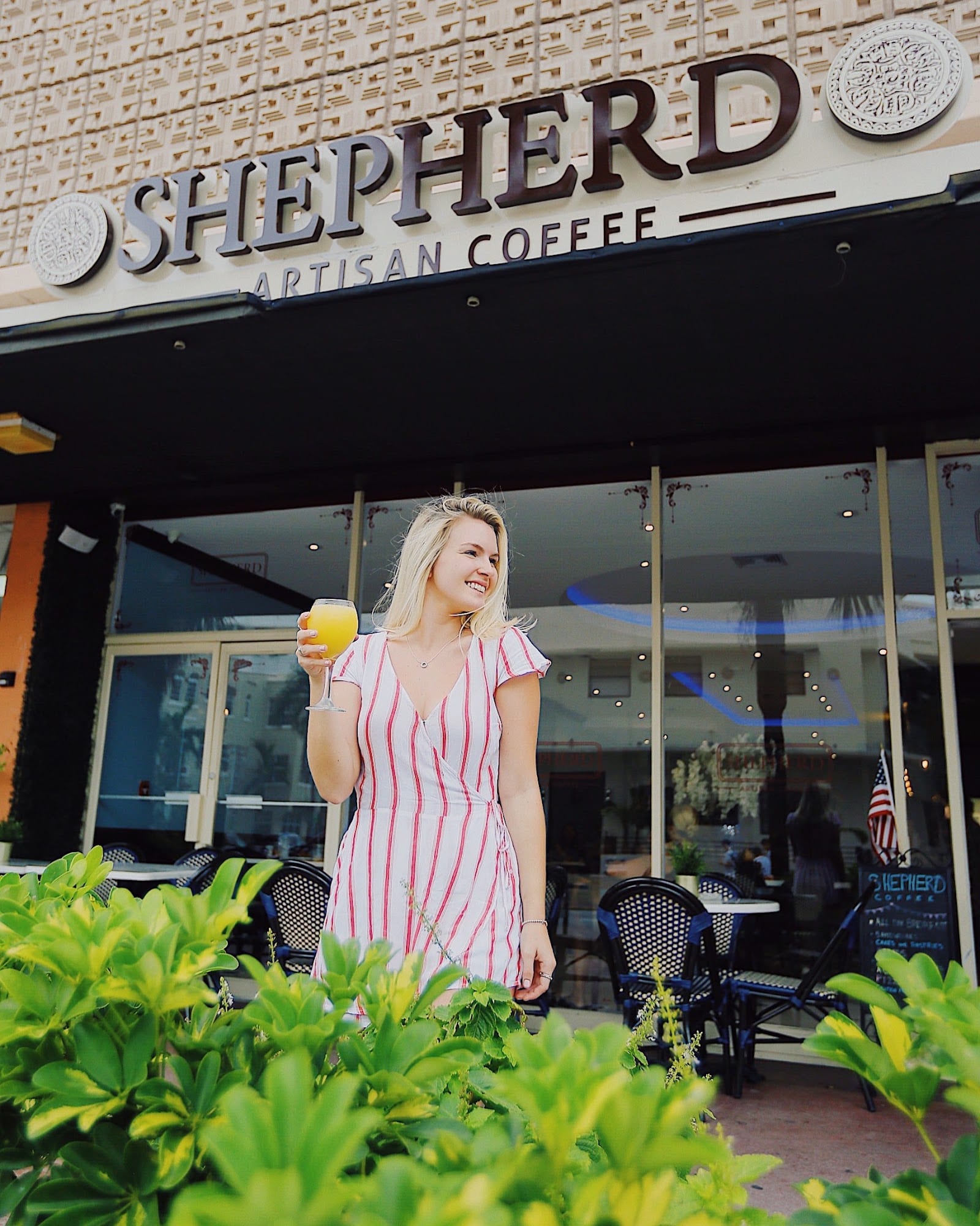 The Shepherd Artisan Coffee storefront and sidewalk tables on Collins Avenue in South Beach