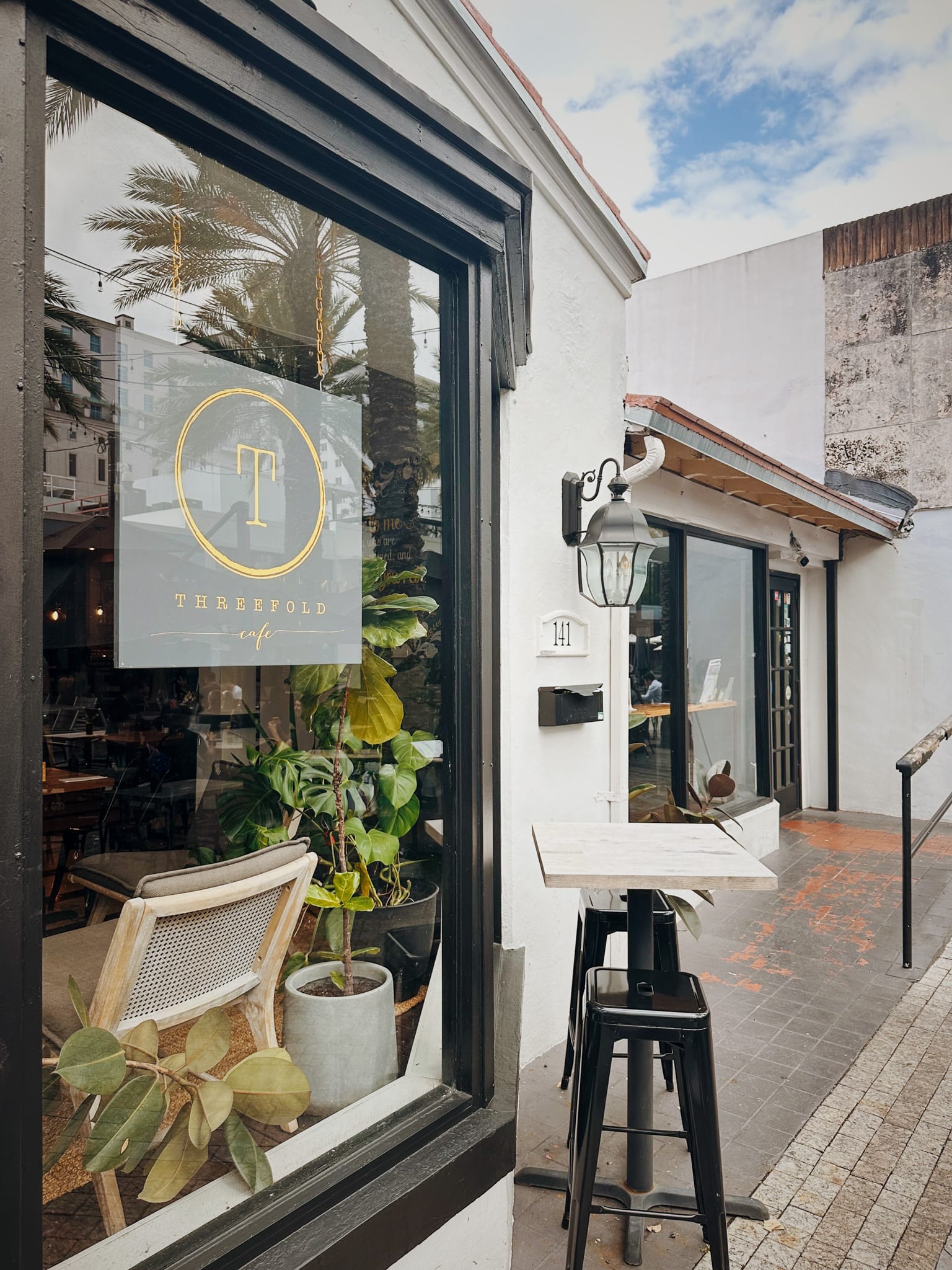The Threefold Cafe window and sidewalk seating at 141 Giralda Avenue in Coral Gables