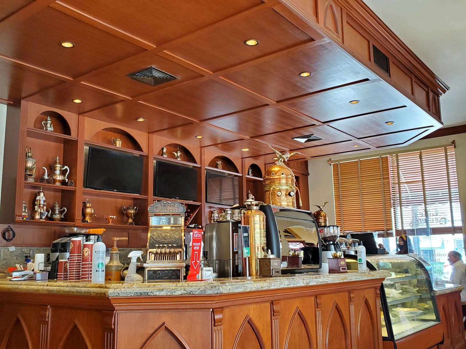 The wood panelled coffee bar and brass espresso machine at Cafe Demetrio in Coral Gables