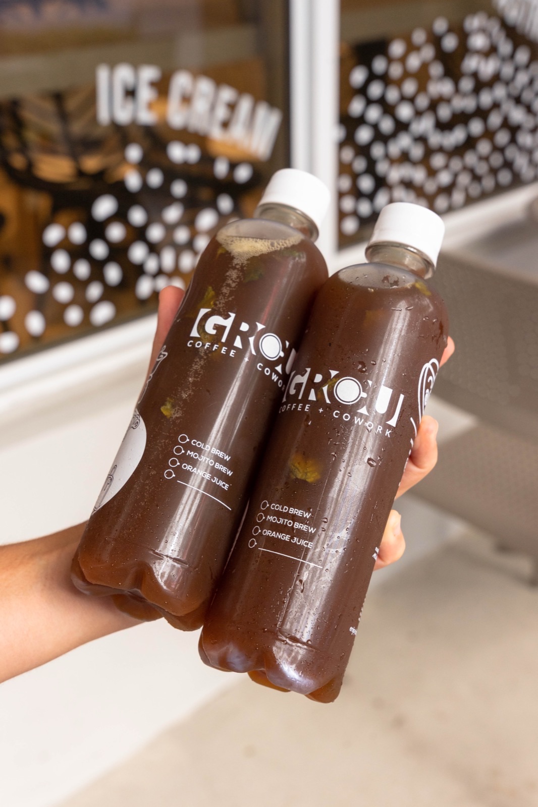 Two bottles of GROU Mojito Brew cold brew held outside the shop