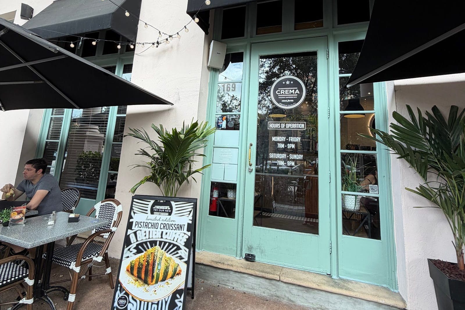 Sidewalk tables under umbrellas outside Crema Gourmet on Miracle Mile, Coral Gables