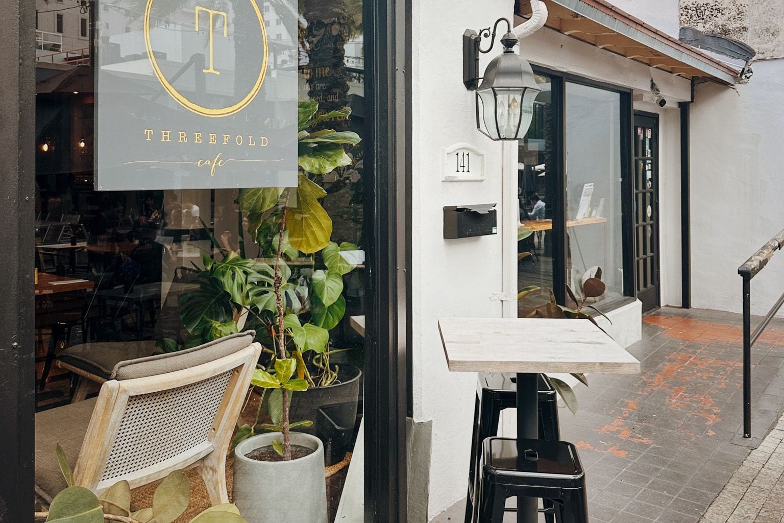 Outdoor seating and plants outside Threefold Cafe on the Giralda pedestrian plaza, Coral Gables