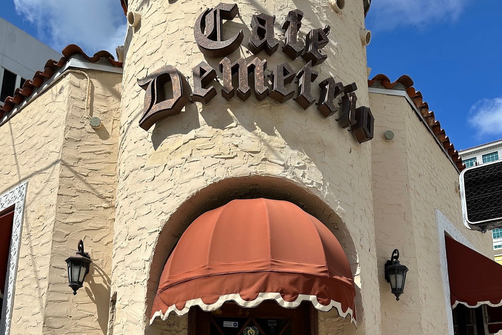 The corner facade and awning of Cafe Demetrio on Alhambra Circle in Coral Gables