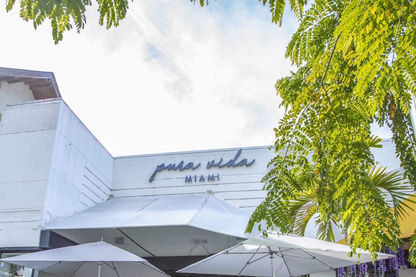 Umbrellas and outdoor seating outside Pura Vida on Miracle Mile in Coral Gables